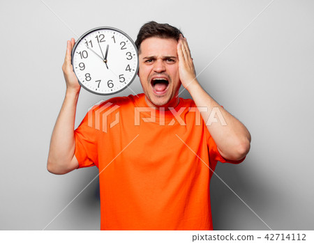 man in orange t-shirt with big clock 42714112