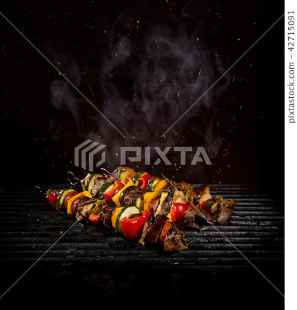 Chicken skewers on the grill with flames 42715091