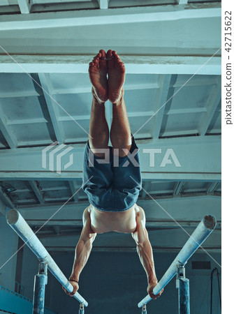 The sportsman during difficult exercise, sports gymnastics The sportsman during difficult exercise, sports gymnastics 42715622