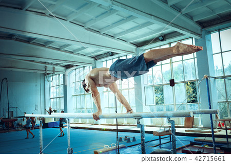 The sportsman during difficult exercise, sports gymnastics The sportsman during difficult exercise, sports gymnastics 42715661