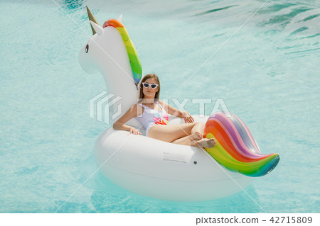 A young beautiful girl with a beautiful figure in a swimsuit and sunglasses is resting and tanning A young beautiful girl with a beautiful figure in a swimsuit and sunglasses is resting and tanning 42715809