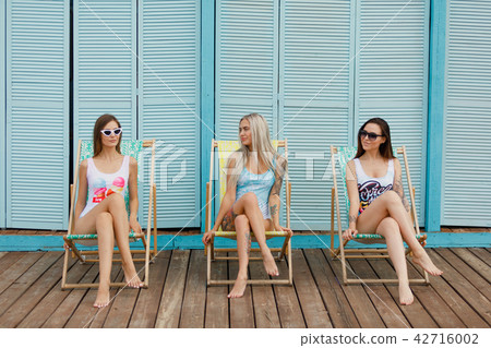 summer holidays and vacation - girls sunbathing on the beach on the bright background. summer 42716002