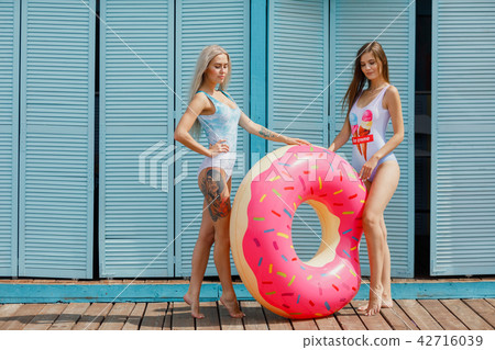 Two happy girls rest on the sea. happy girls on the beach. beautiful girlfriends with inflatable Two happy girls rest on the sea. happy girls on the beach. beautiful girlfriends with inflatable 42716039