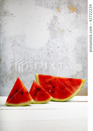 Pieces of watermelon on a wooden table Pieces of watermelon on a wooden table 42722234