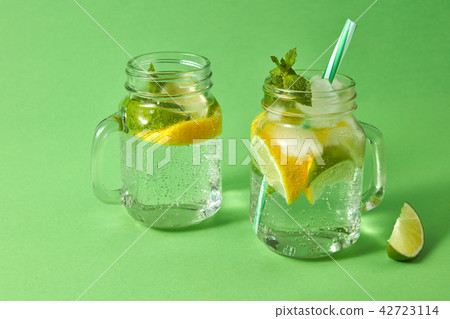 Summer refreshing drink on a green background. Homemade sparkling cocktail in glass jars. Concept of 42723114