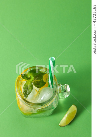 Sparkling fresh cold homemade lemonade with ice, slices of lime and lemon, leaf of mint with plastic 42723165