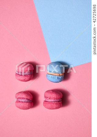 Set of three pink and blue macaroons on a blue pink paper background. Top view 42725698