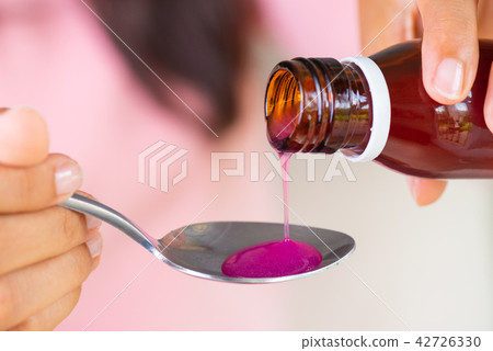 Woman hand pouring antipyretic syrup from bottle Woman hand pouring antipyretic syrup from bottle 42726330