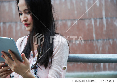 Beautiful girl happy playing tablet device working Beautiful girl happy playing tablet device working 42726504