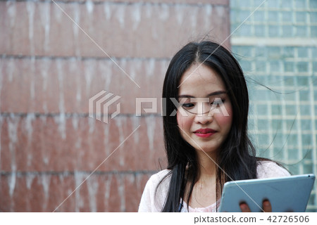 Beautiful girl happy playing tablet device working Beautiful girl happy playing tablet device working 42726506