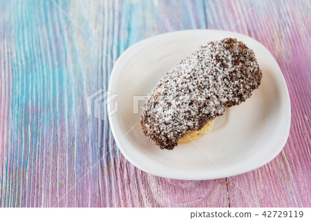 Tasty eclair on plate Tasty eclair on plate 42729119