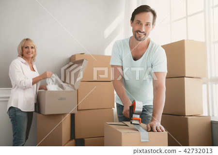 Packing Boxes with Building Tape in Order to Move. Packing Boxes with Building Tape in Order to Move. 42732013