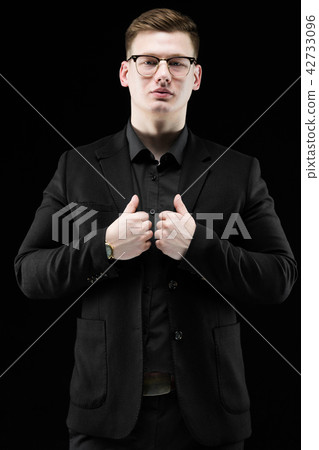 Portrait of confident handsome elegant responsible businessman in glasses holding hands on his suit Portrait of confident handsome elegant responsible businessman in glasses holding hands on his suit 42733096
