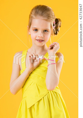 Girl posing on yellow background. 42733647