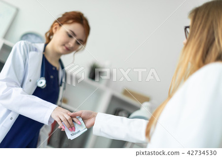 A beautiful young girl in a white robe is standing near a computer desk in the office and A beautiful young girl in a white robe is standing near a computer desk in the office and 42734530