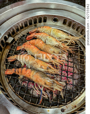 Grilling prawn on charcoal stove 42735942