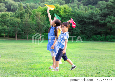 孩子們在公園玩紙飛機。 42736377