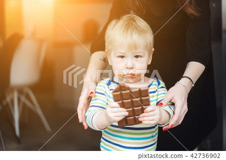 Portrait of an littel boy eating chocolate Portrait of an littel boy eating chocolate 42736902