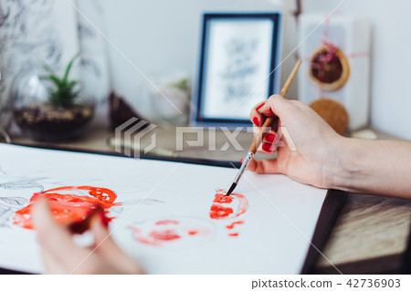 Young woman painting with watercolor paints 42736903