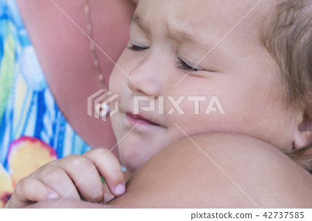 Child sleeps with his mother in arms Child sleeps with his mother in arms 42737585