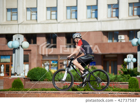 Male cyclist training on street edge Male cyclist training on street edge 42737587