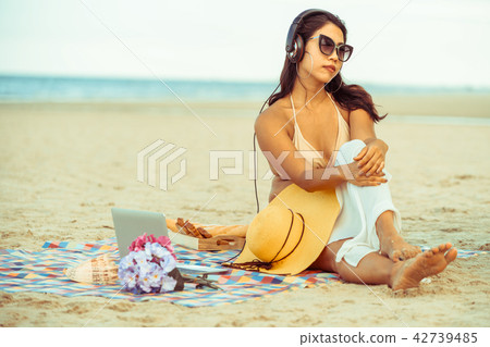 Plus size young woman sitting on the beach. 42739485
