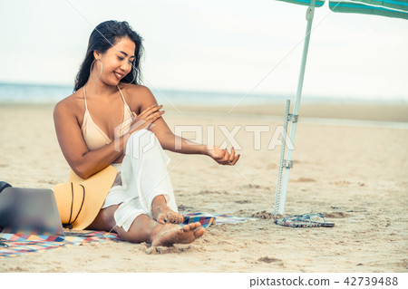 Plus size young woman sitting on the beach. 42739488