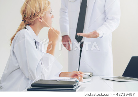 Female doctor at hospital talking to her partner. Female doctor at hospital talking to her partner. 42739497