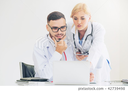 Doctor at hospital works on computer with partner. 42739498