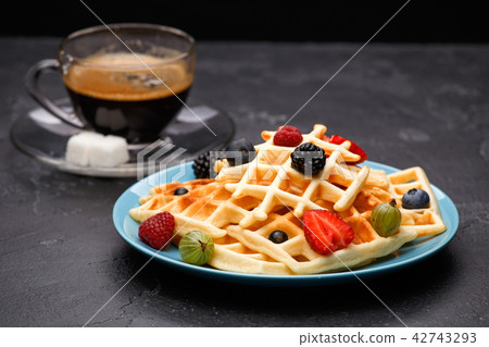 Photo of cup of coffee with Belgian wafers with strawberries, raspberries 42743293
