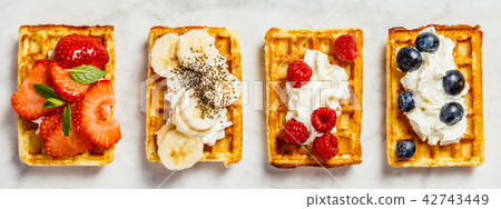 Traditional belgian waffles with whipped cream and fresh fruits Traditional belgian waffles with whipped cream and fresh fruits 42743449