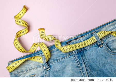 Jeans and yellow measuring tape instead of belt Jeans and yellow measuring tape instead of belt 42745019