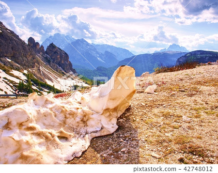 The rest of dirty snow at road in spring mountains 42748012