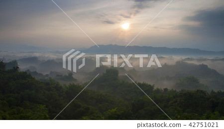 Mist-shrouded mountains with yellow sunrise Mist-shrouded mountains with yellow sunrise 42751021