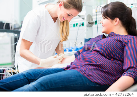 Nurse applying access at upper arm of patient 42752264