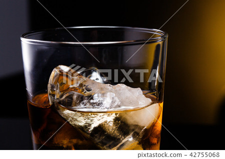 a glass with whiskey and ice on a background 42755068
