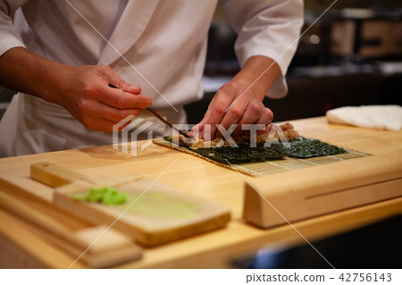 Professional sushi chef is making maki sushi roll Professional sushi chef is making maki sushi roll 42756143