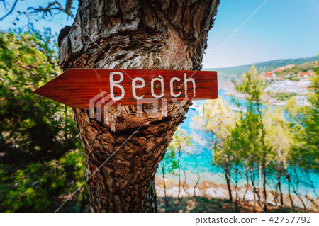 Assos village in morning light, Kefalonia. Greece. Beach wooden arrow sign on a pine tree showing 42757792