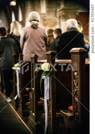 Beautiful flower wedding decoration in a church hang on the seat rows setting in the Chapel Beautiful flower wedding decoration in a church hang on the seat rows setting in the Chapel 42765487