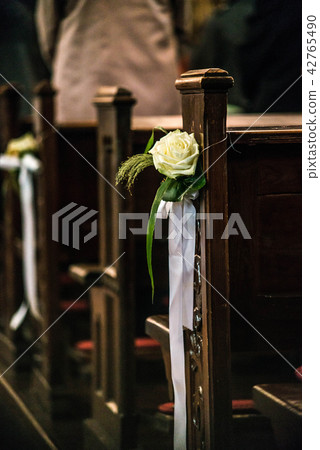 Beautiful flower wedding decoration in a church hang on the seat rows setting in the Chapel 42765490