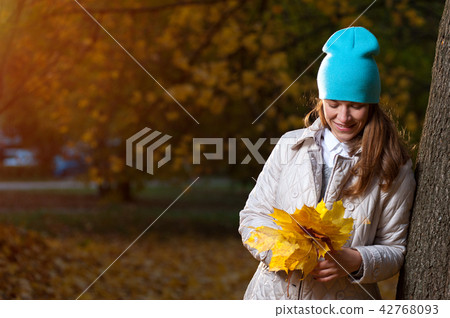 Beautiful autumn woman with yellow fall leaves 42768093