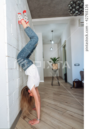 A woman is standing on his hands upside down 42768136