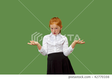 Beautiful teen girl looking suprised and bewildered isolated on green 42770108