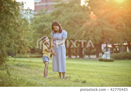 Mother and child talking together on the lawn Mother and child talking together on the lawn 42770485