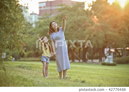 Mother and child talking together on the lawn Mother and child talking together on the lawn 42770486