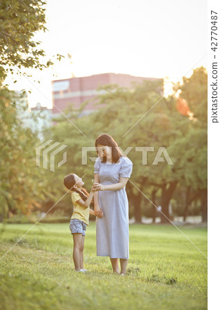 Mother and child talking together on the lawn Mother and child talking together on the lawn 42770487
