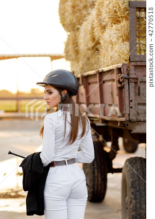 rider woman in helmet stands near stables rider woman in helmet stands near stables 42770518