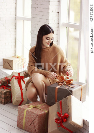 Beautiful girl in sweater sitting on the window. G 42771068