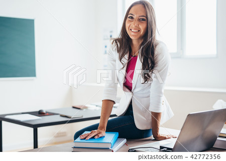 Portrait of female student with book smiling at camera 42772356
