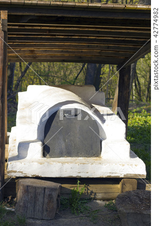 Old summer oven in yard under wooden canopy 42774982